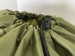 Close up of army green polyester laundry bag and its toggle with drawstring closure
