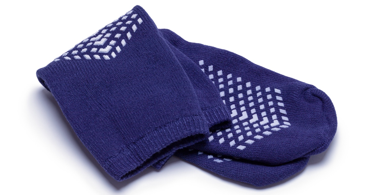 A pair of trampoline grip socks with textured soles lying flat with the anti slip pattern visible on the bottom.