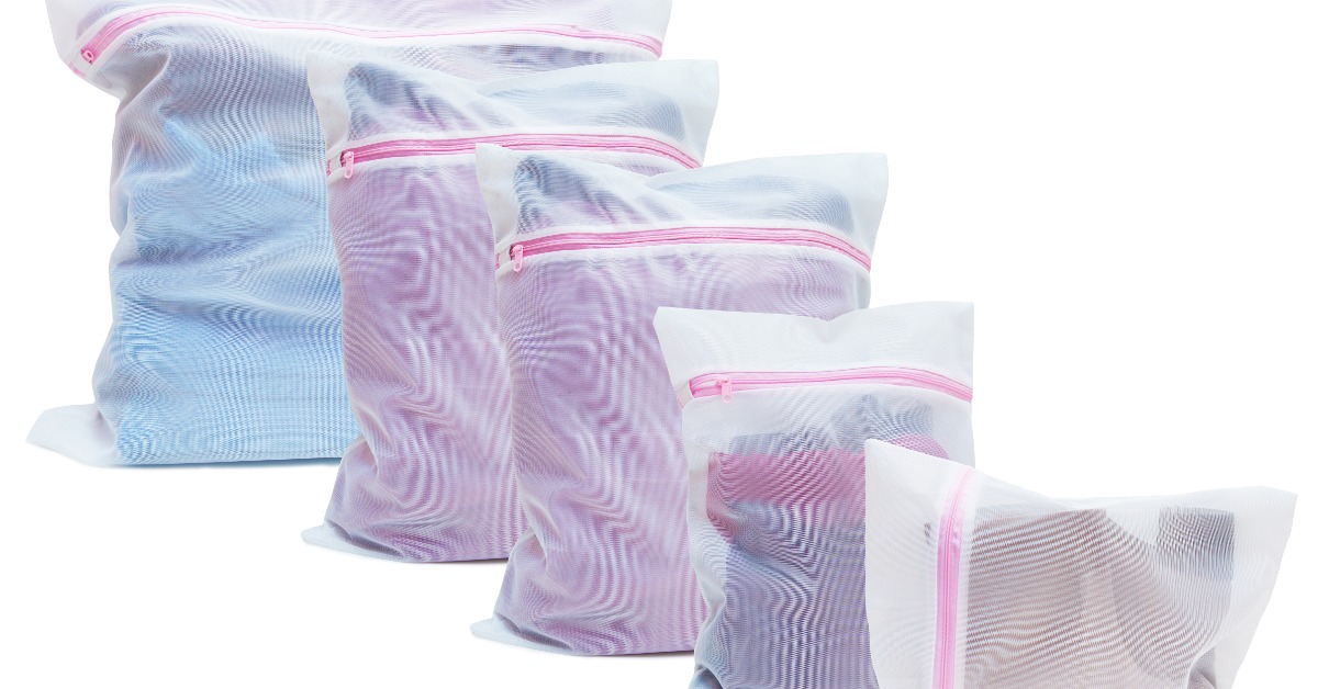 Five white mesh laundry bags filled with clothing, arranged in different sizes with pink zippers on a white background.