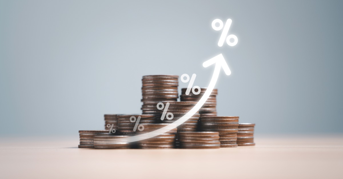 A row of coin stacks arranged by height with an upward arrow and percentage symbols placed above the coins.