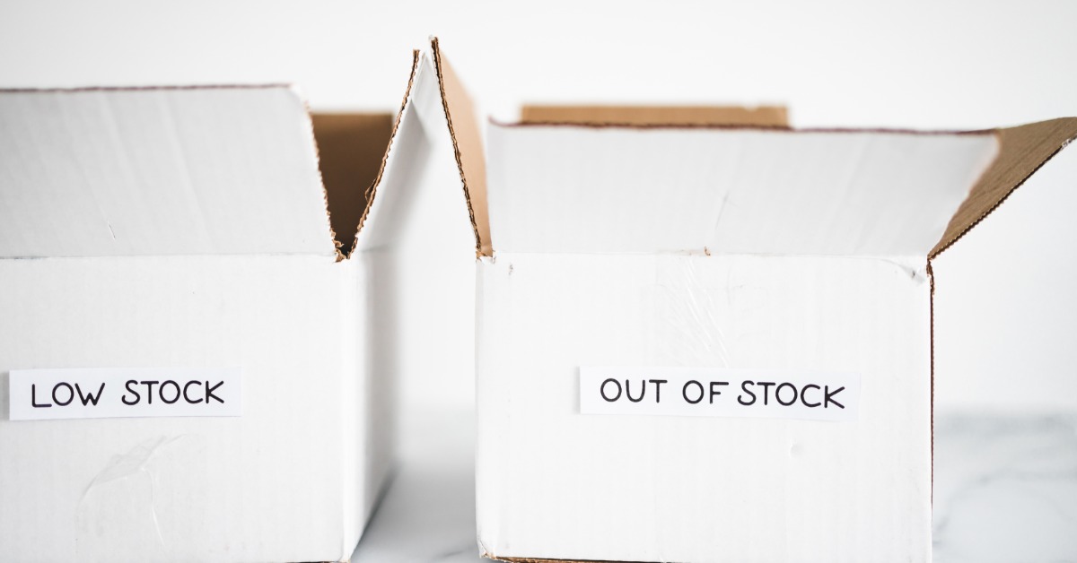 Two white cardboard boxes printed with low stock and out of stock text arranged against a white background